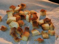 Pieczywo kroimy w kostkę, skrapiamy oliwą,...