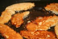 Nuggetsy stopniowo maczamy w cieście i smażymy...