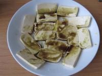 Tofu kroimy na plasterki. Połowę rozkładamy na...